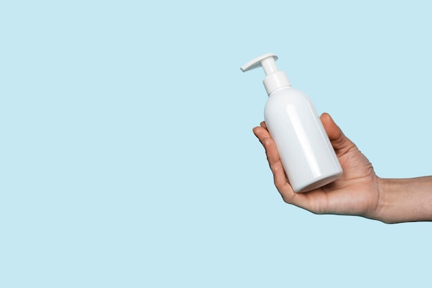 Woman holding a liquid soap bottle with copy space