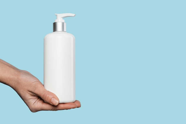 Woman holding a liquid soap bottle with copy space