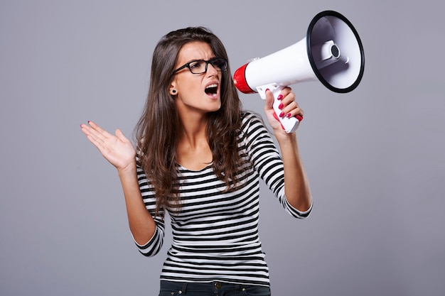 Woman holding a loudspeaker and screaming through it