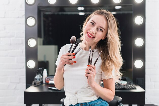 Woman holding makeup brushes in studio