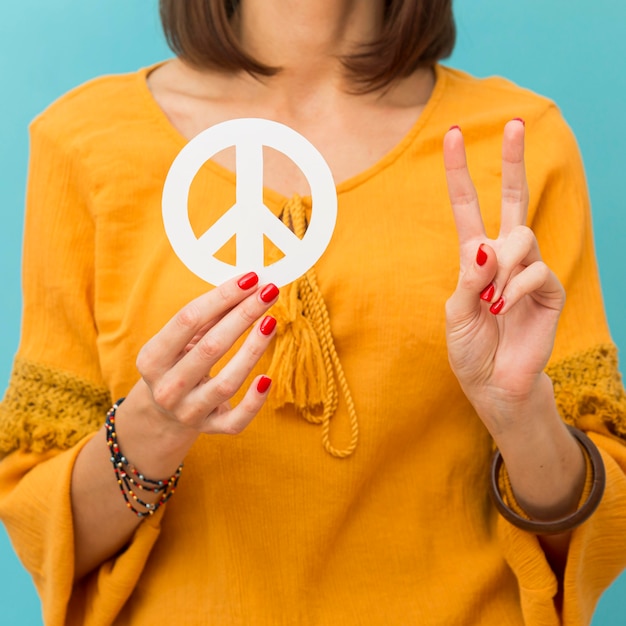 Free photo woman holding and making peace sign