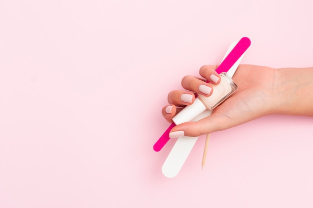 Woman holding manicure tools with copy space