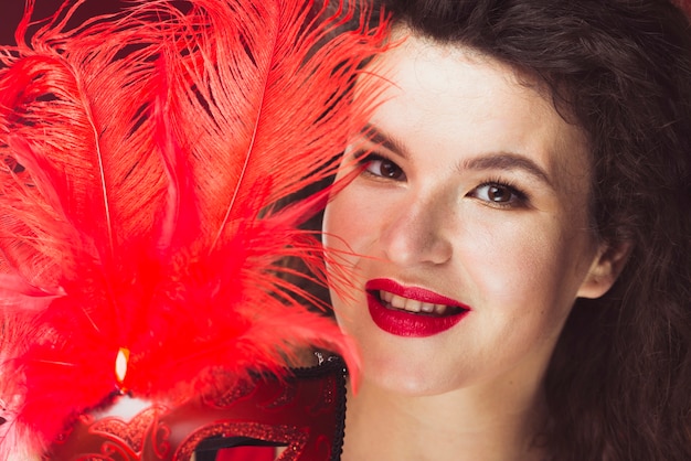 Free photo woman holding mask with feathers