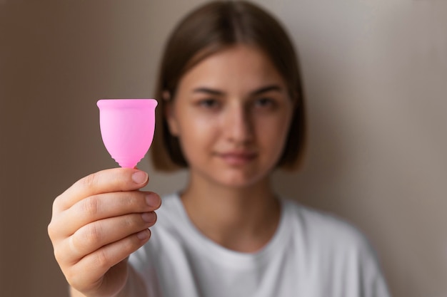 Бесплатное фото Женщина держит менструальную чашу, вид спереди