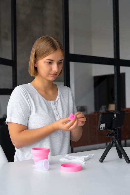 Foto gratuita vista laterale della tazza mestruale della tenuta della donna