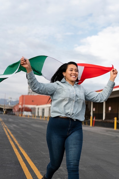 通りでメキシコの旗を保持している女性