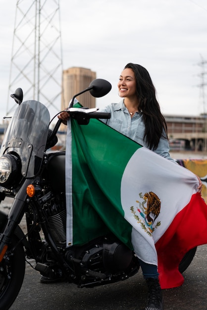 通りでメキシコの旗を保持している女性