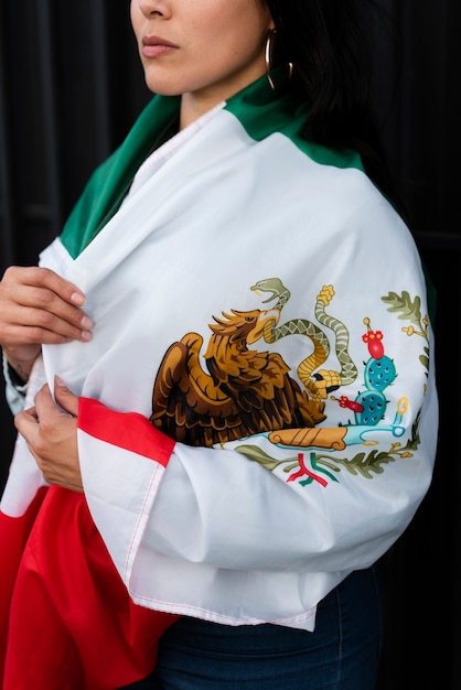 Donna che tiene bandiera messicana in strada