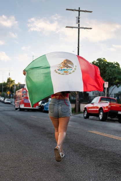 Woman holding mexican flag in the street