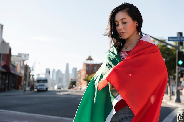 Free photo woman holding mexican flag in the street