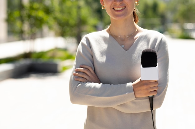 Foto gratuita donna che tiene un microfono per un'intervista