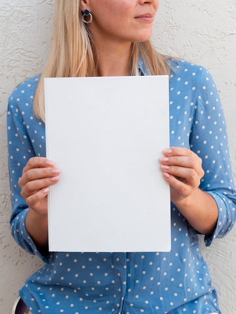 Free photo woman holding a mock-up magazine