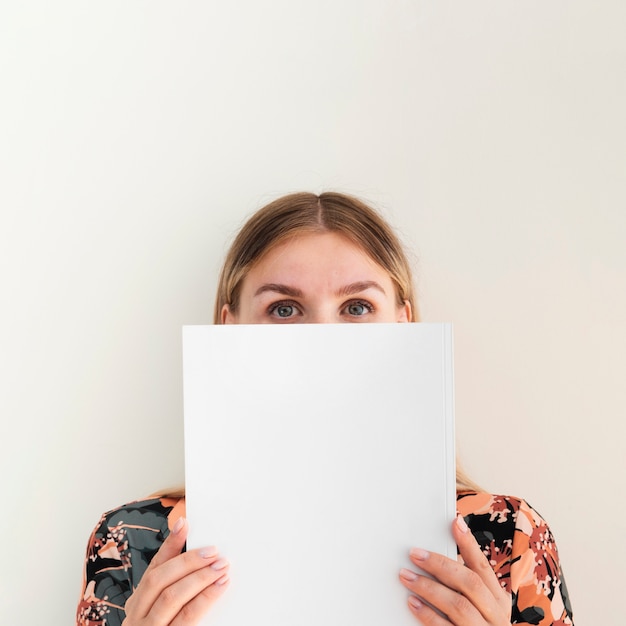 Free photo woman holding a mock-up magazine