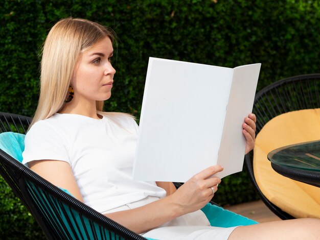 Free photo woman holding a mock-up magazine