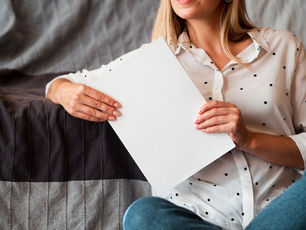 Free photo woman holding a mock-up magazine