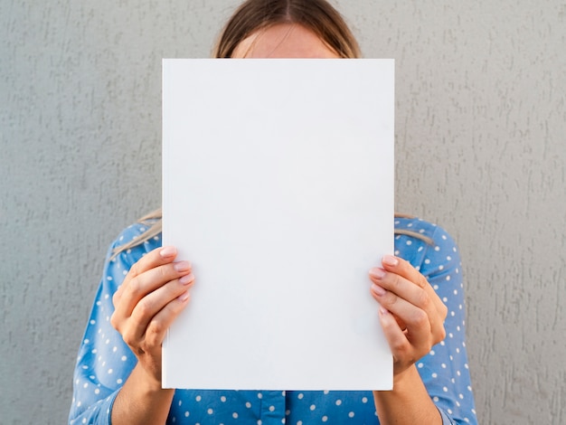 Free photo woman holding a mock-up magazine