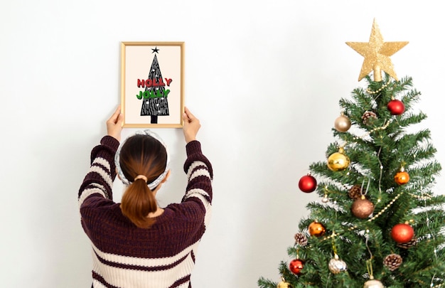 Foto gratuita donna che tiene il design del telaio mockup per la decorazione il giorno di natale