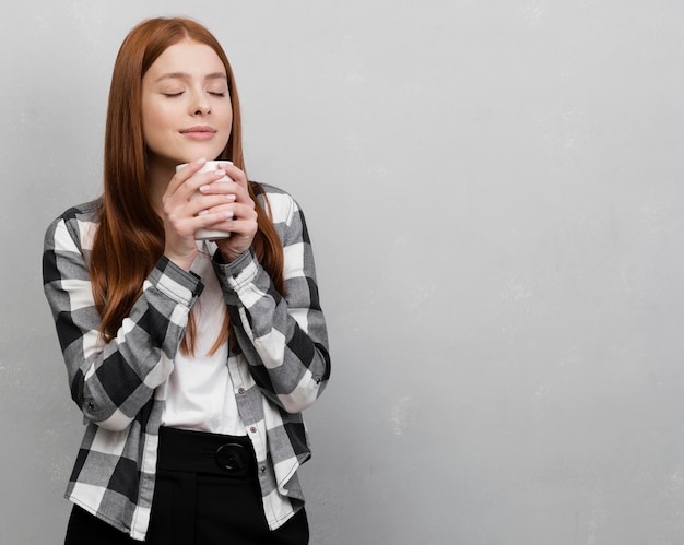 Foto gratuita donna che tiene lo spazio della copia della tazza