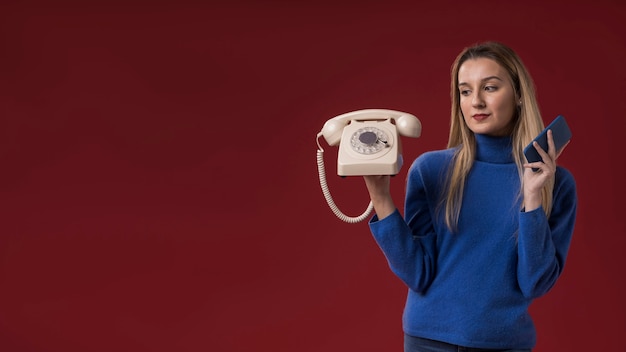 Бесплатное фото Женщина держит старый и новый телефон