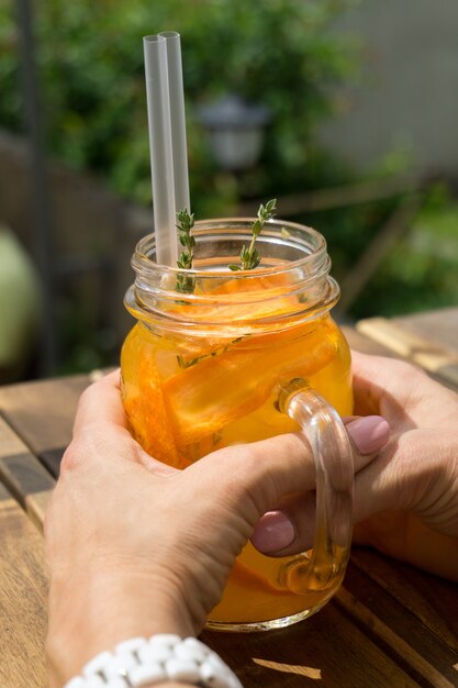 Woman holding an orange lemonade