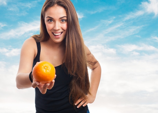 Woman holding an orange while smiling