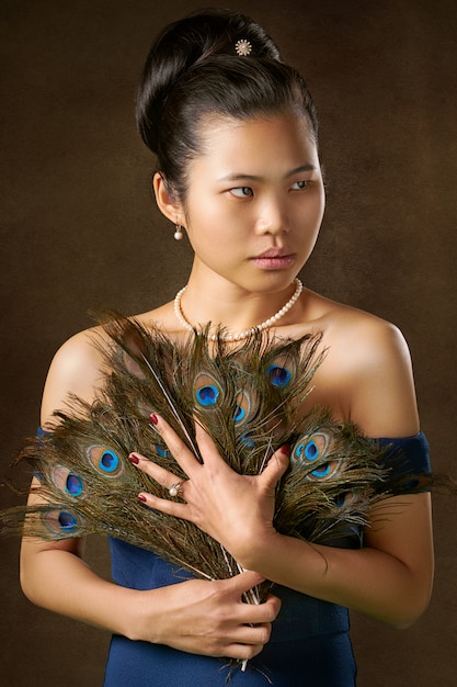 Free photo woman holding peacock feathers