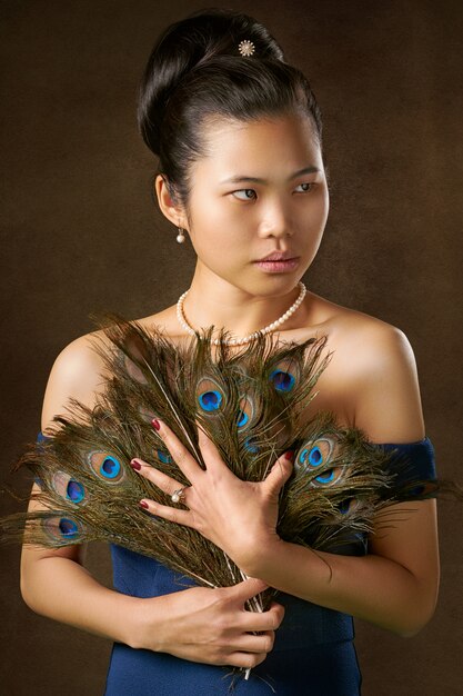 Woman holding peacock feathers 