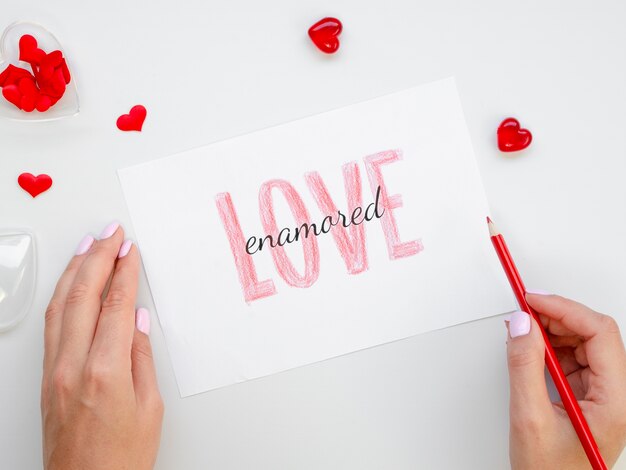 Woman holding pencil and love paper