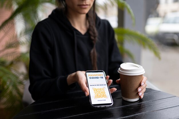 Foto gratuita donna che tiene telefono e tazza di caffè