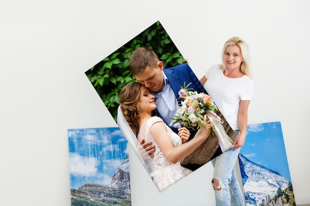 woman holding photo canvas on the background of a interior.