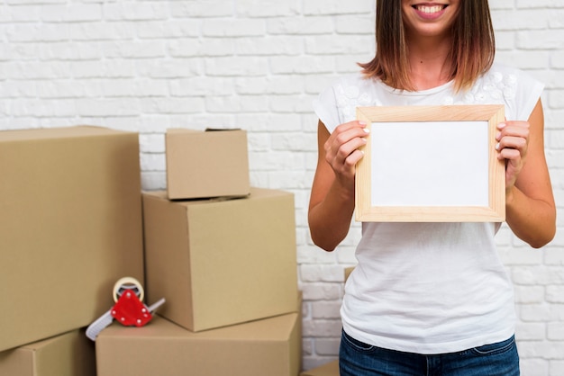 Free photo woman holding a photo frame mock-up