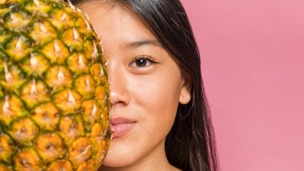 Woman holding a pineapple and smile