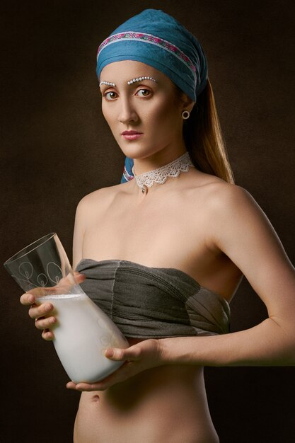 Женщина держит кувшин из стекла с молоком