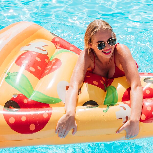 Woman holding a pizza swimming float