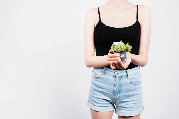 Free photo woman holding plant in bucket