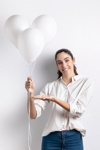 Woman holding and pointing at balloons