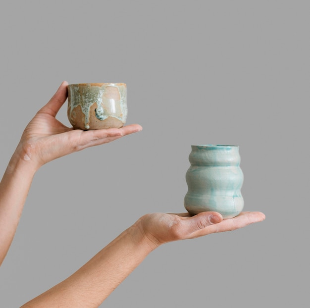 Woman holding pottery pieces made by herself