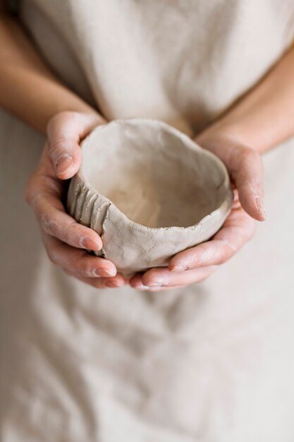 Woman holding pottery pieces made by herself