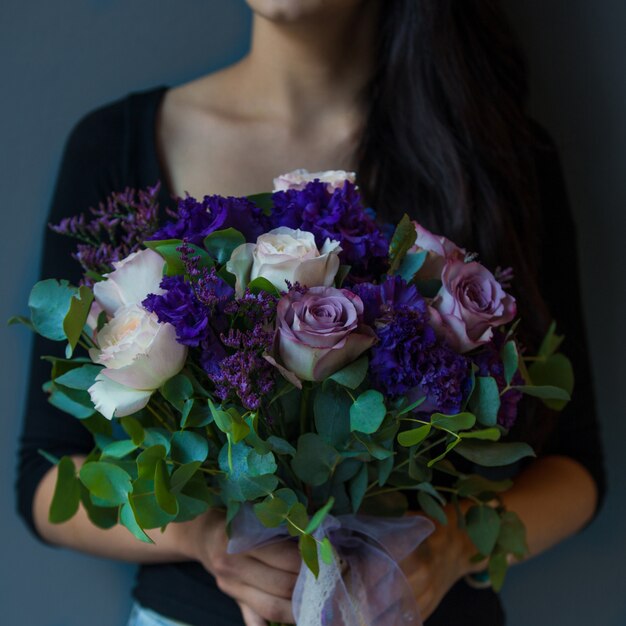 紫、白のバラの花束を保持している女性