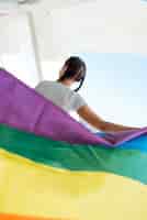 Бесплатное фото Женщина держит флаг радуги