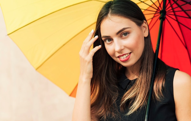 Foto gratuita donna che tiene un ombrello arcobaleno