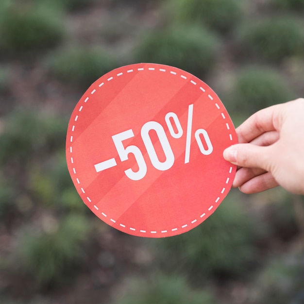 Woman holding red sale sign