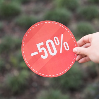 Woman holding red sale sign