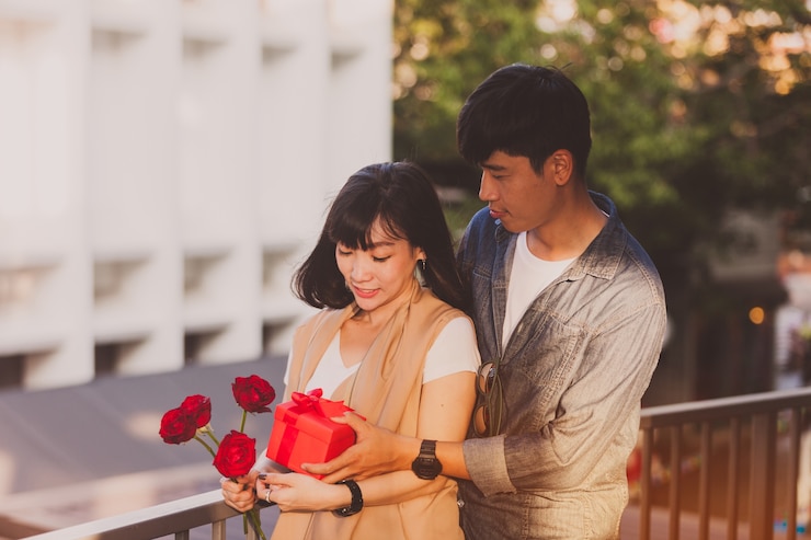 무료 Photo 그녀의 남자 친구가 그녀에게 선물 상자를주는 동안 장미를 들고 여자