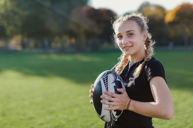 Woman holding a rugby ball with copy paste