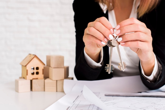 Free photo woman holding a set of keys with wooden cubes