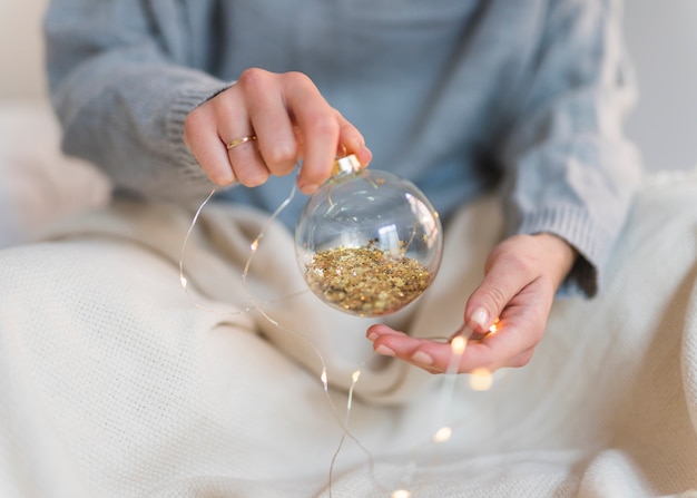 Woman holding shiny bauble in hand 