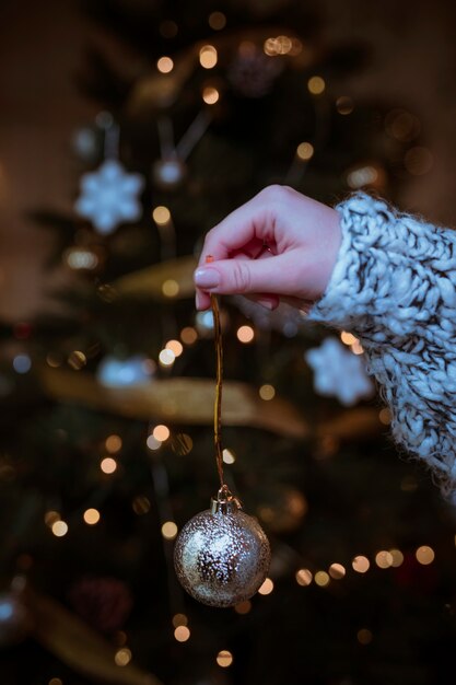 Woman holding shiny bauble in hand 