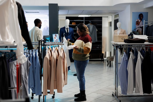 Woman holding shirt shopping in store