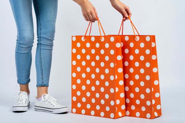 Woman holding shopping bags mock-up near legs